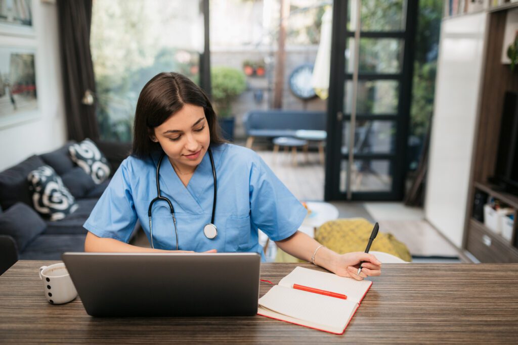 Beautiful female doctor checking her patients from home